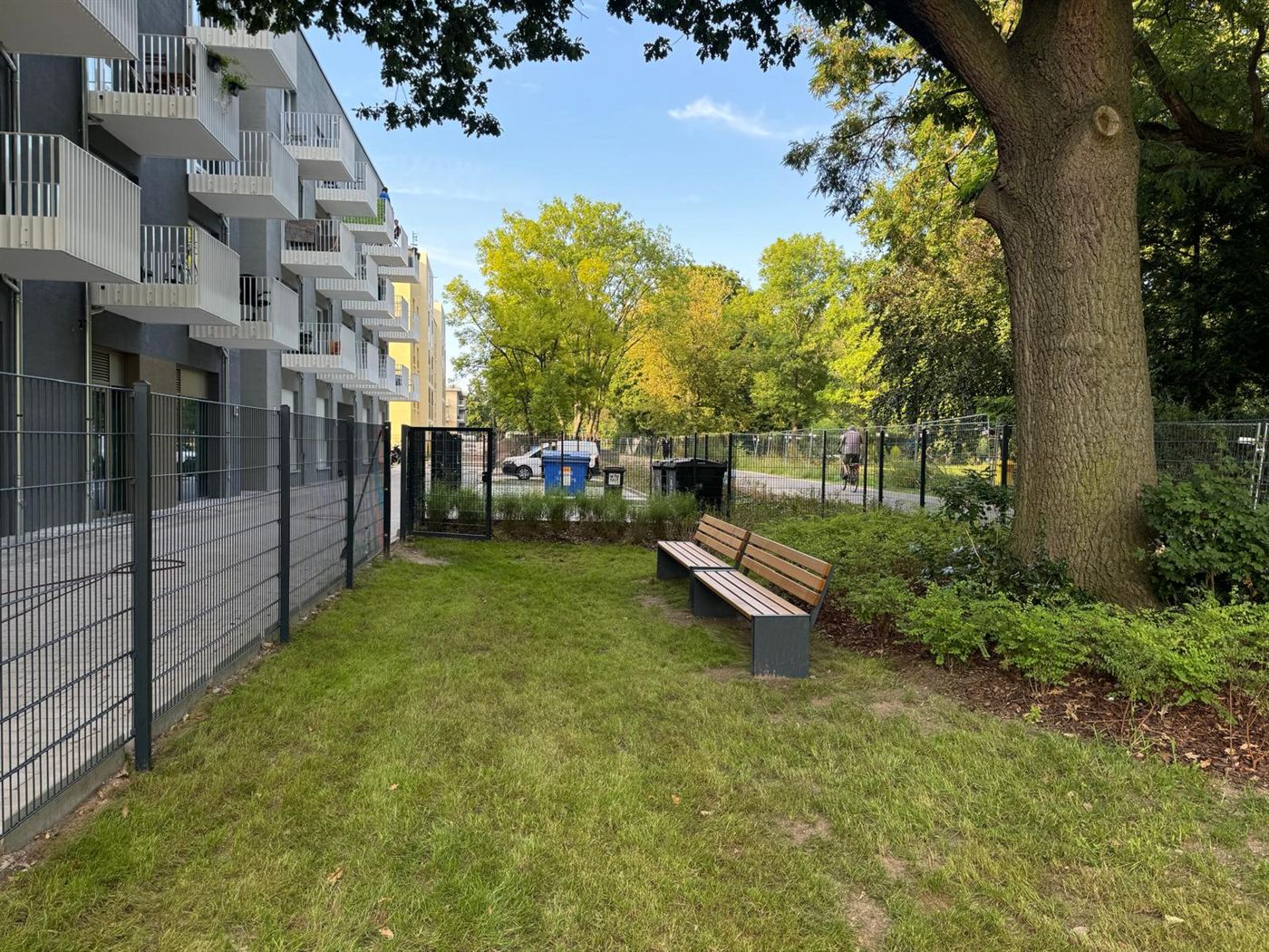 Rasenfläche mit Sitzbänken und Pflanzbeeten an einer neuen Wohnanlage in der Holländerstraße in Berlin